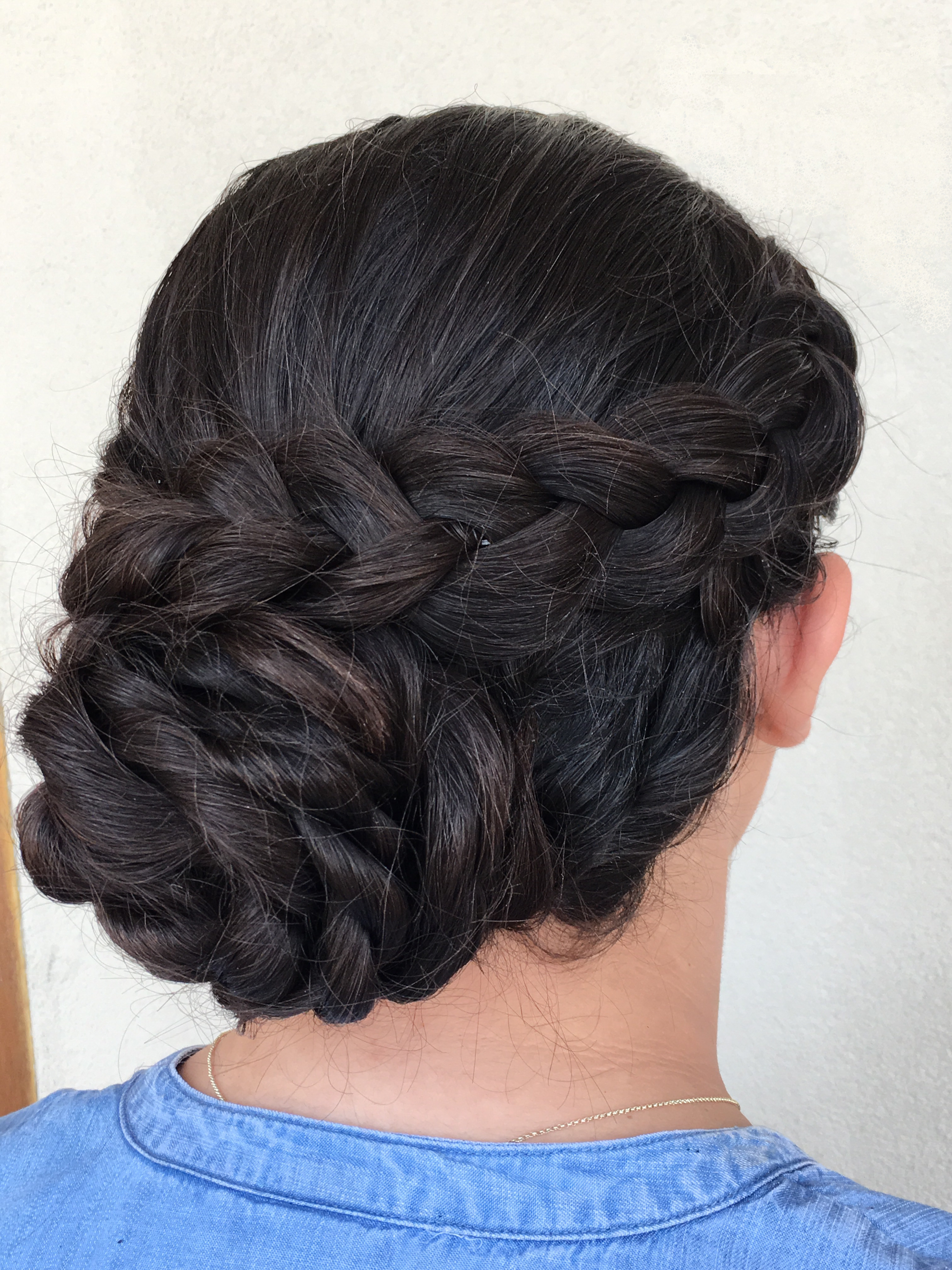 Picture of woman with hair braided and twisted into an elegant updo.